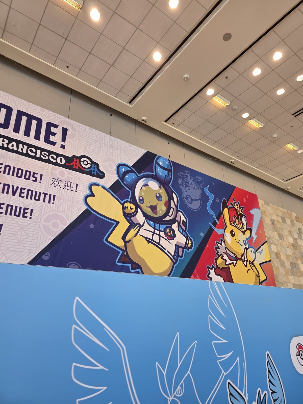 A large mural of Pikachu in an astronaut suit with Welcome written in several languages