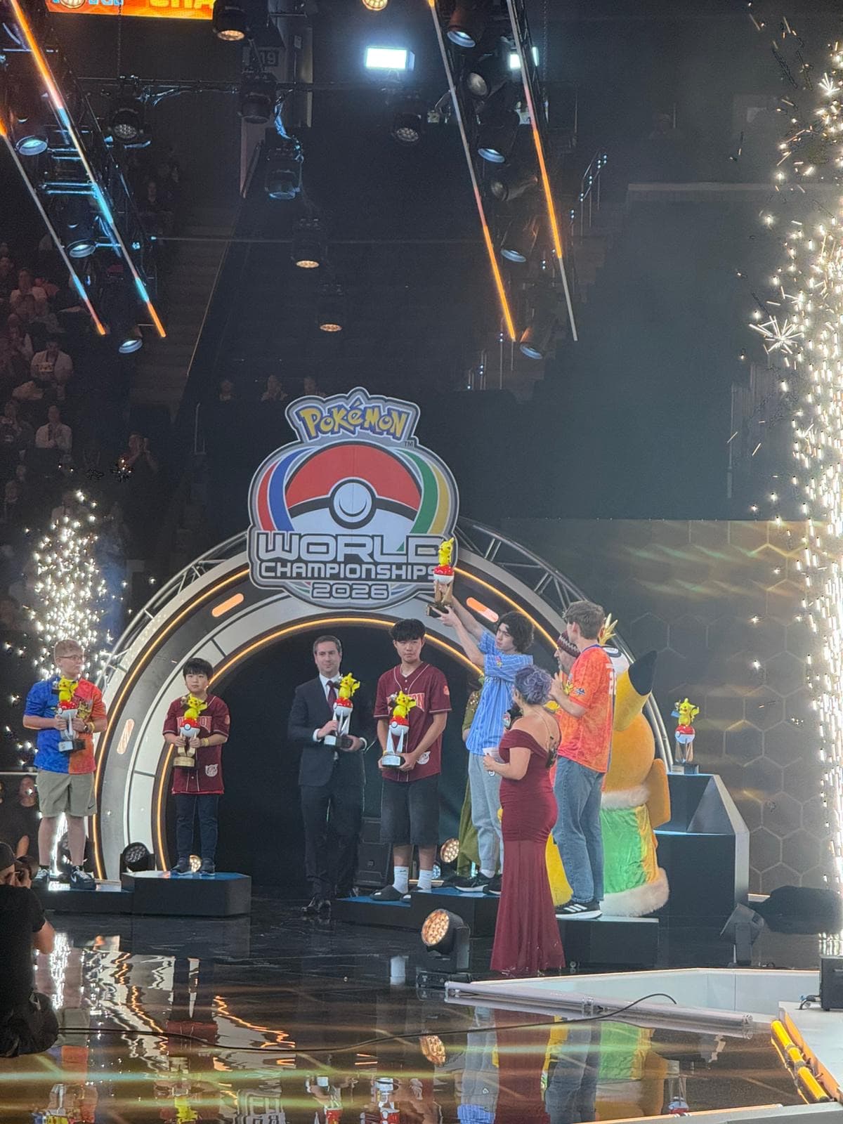 A lit archway on the arena stage with the World Championships logo and people gathered beneath it