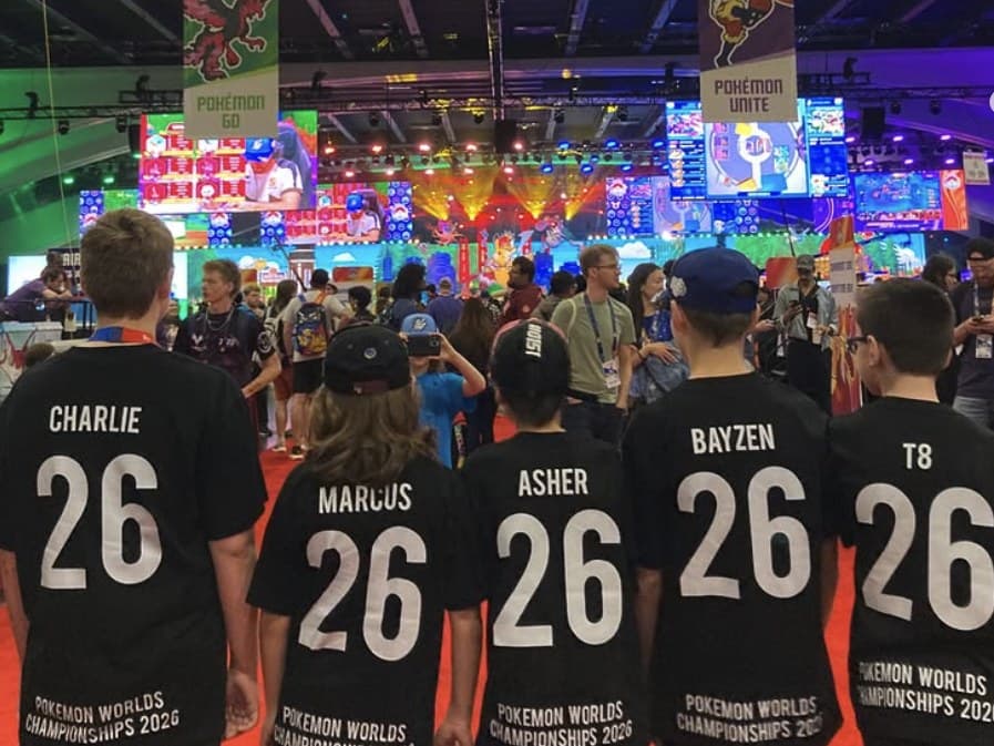 Five young players seen from behind in matching Pokémon Worlds Championships 2026 shirts